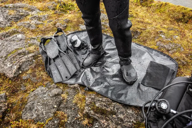 scuba diver standing on a changing mat wearing integrated drysuit boots