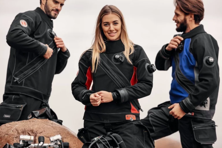 Three scuba divers wearing front entry trilaminate drysuits